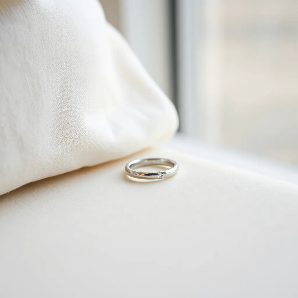 Minimalist ring with a clean band and subtle detail on a light stone with soft natural light