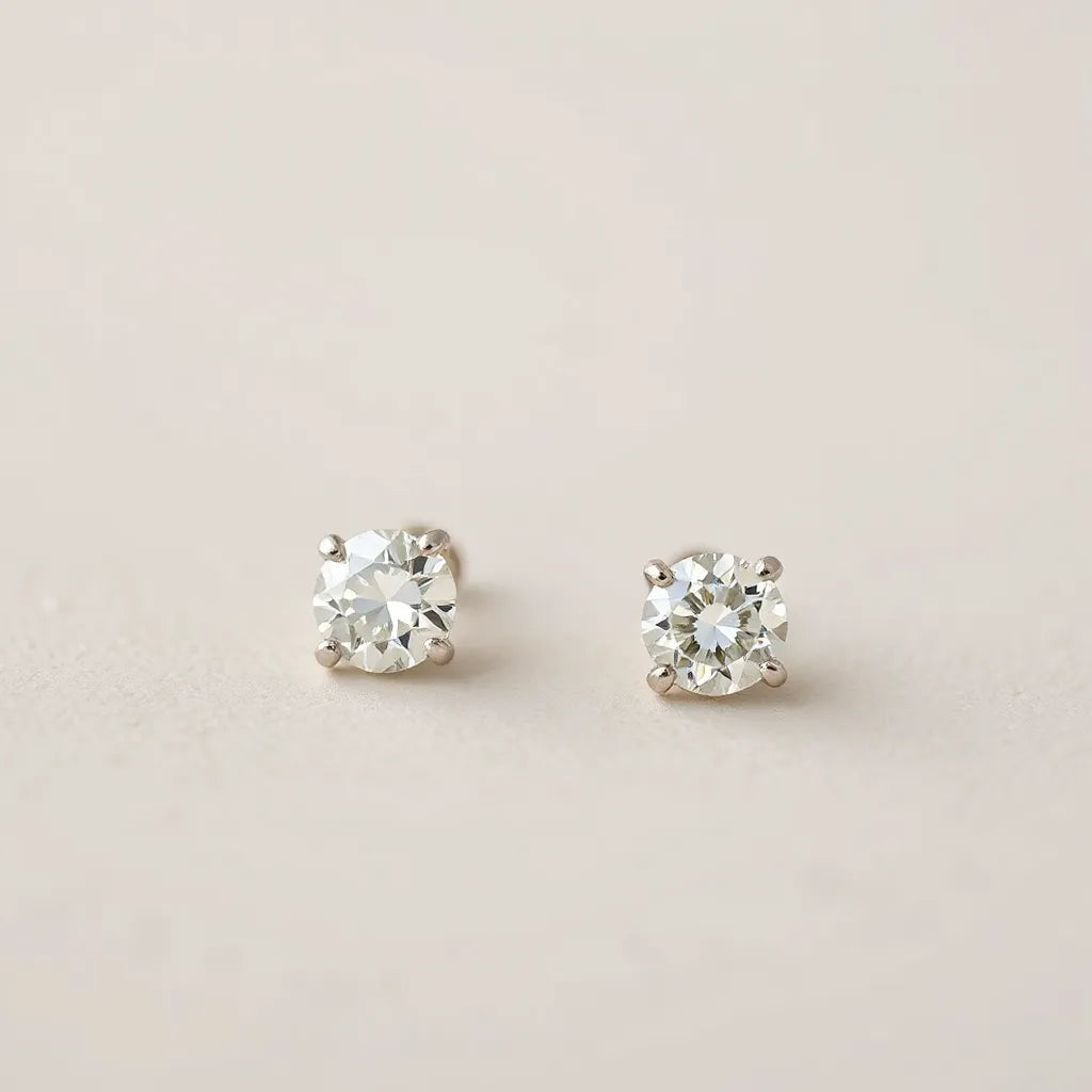 Sparkling pair of diamond earrings with visible diamond facets on a neutral background