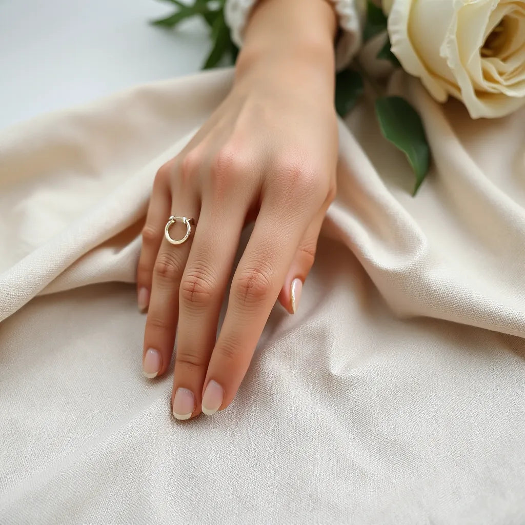 Woman wearing small minimalist stud and hoop earrings in soft natural light