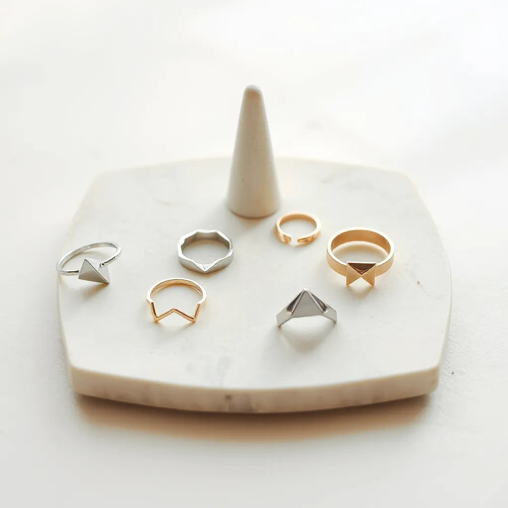 Assorted geometric rings with angular shapes on a neutral surface under soft natural light
