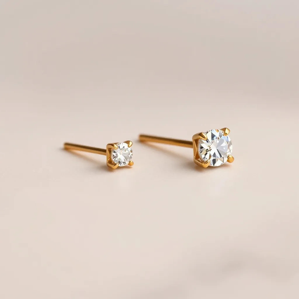 Warm gold diamond stud earrings with visible sparkle on a neutral background