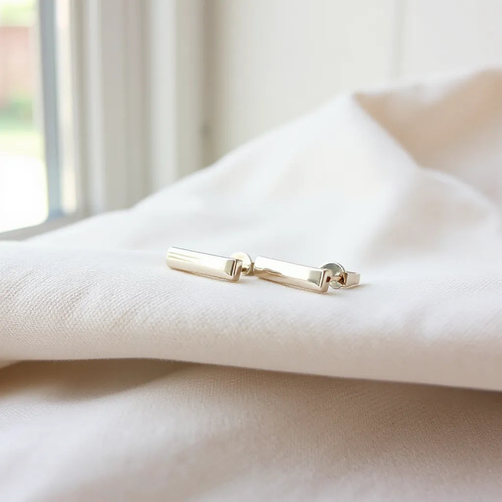 Silver clip earrings resting on light fabric with soft natural lighting and clear earring details