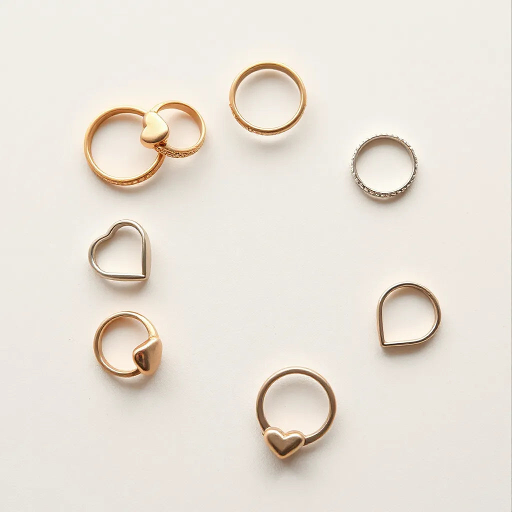 Retro heart-shaped rings in rose gold and silver arranged neatly under soft natural light