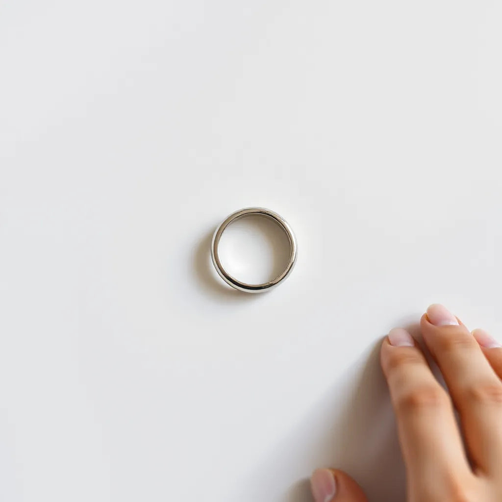 Flat shiny ring with smooth reflective surface on a light neutral background