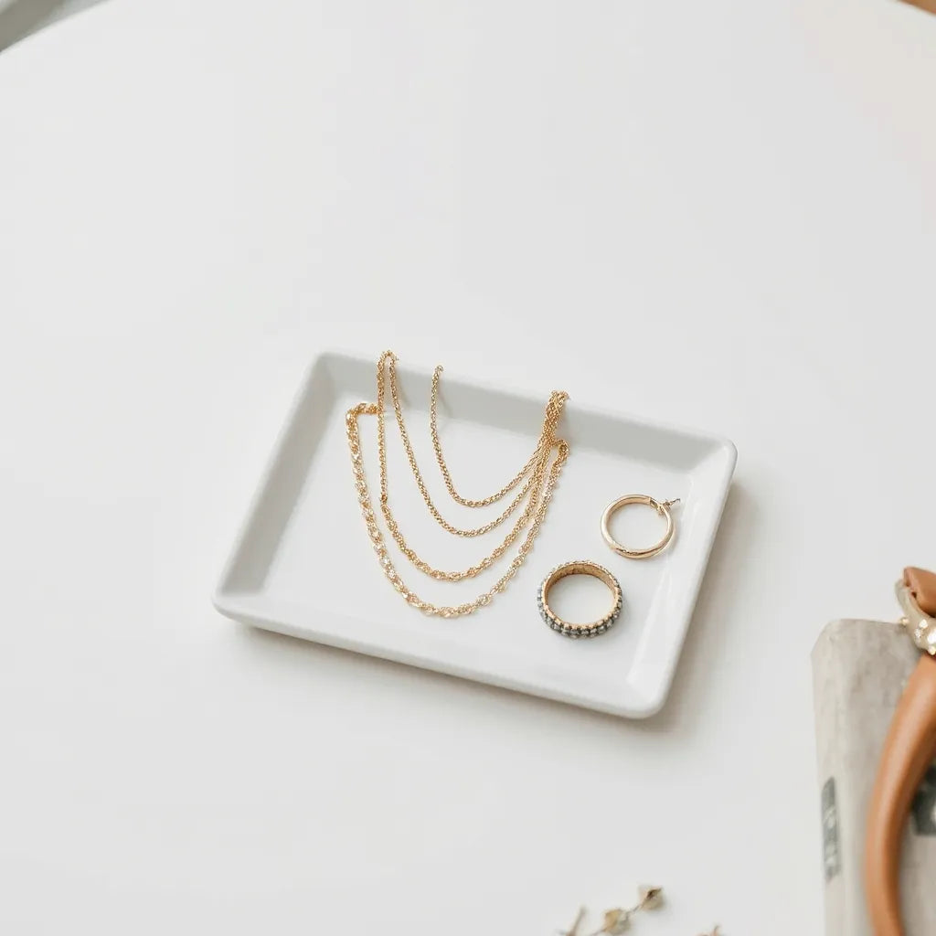 Seasonal layered necklaces, earrings, bracelet, and ring arranged on a neutral jewelry tray