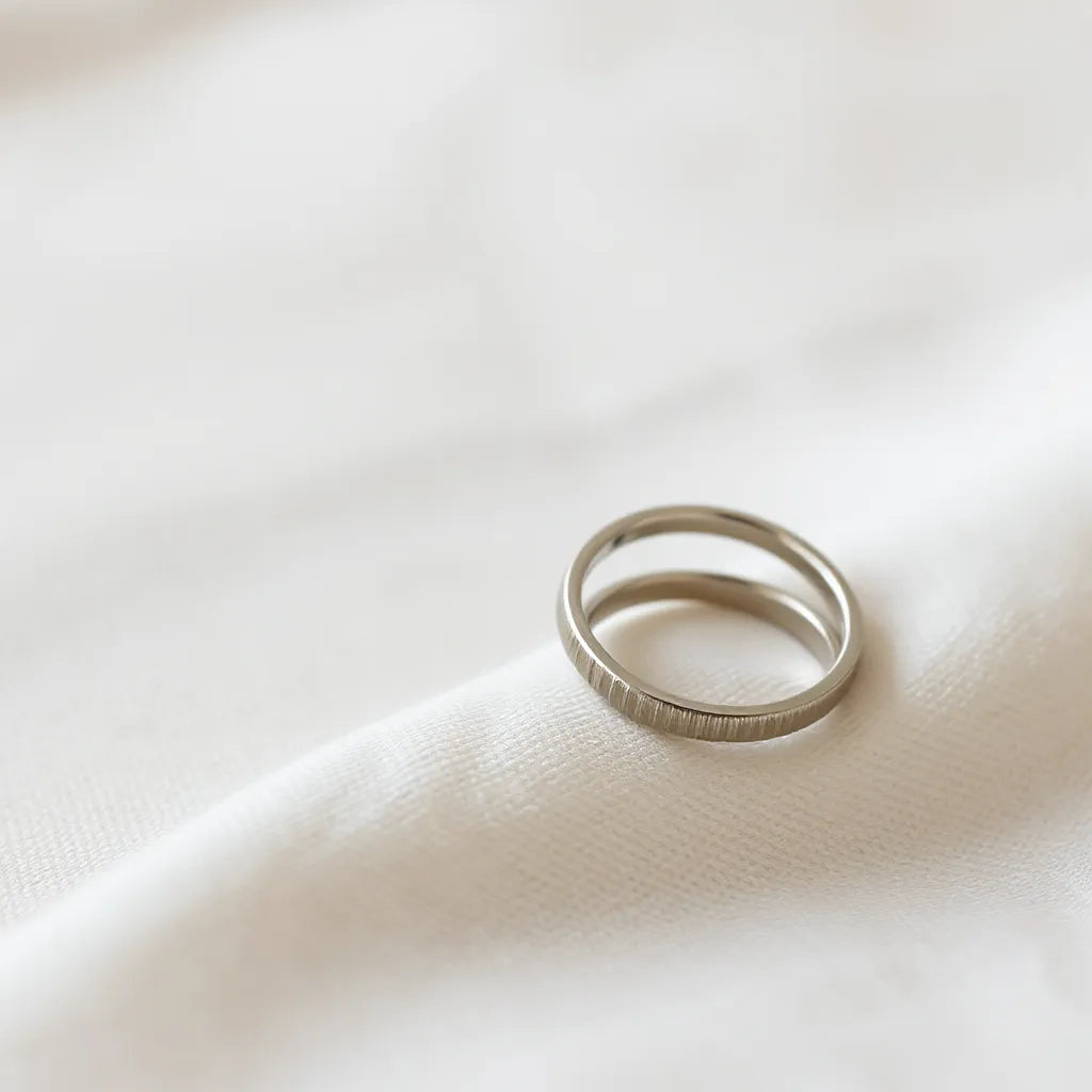 Minimalist Japanese and Korean style rings resting on light fabric under soft natural light