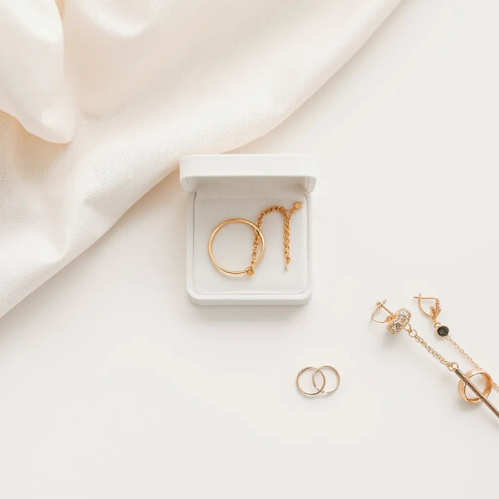 Minimalist gold and silver jewelry accessories arranged on a light neutral surface