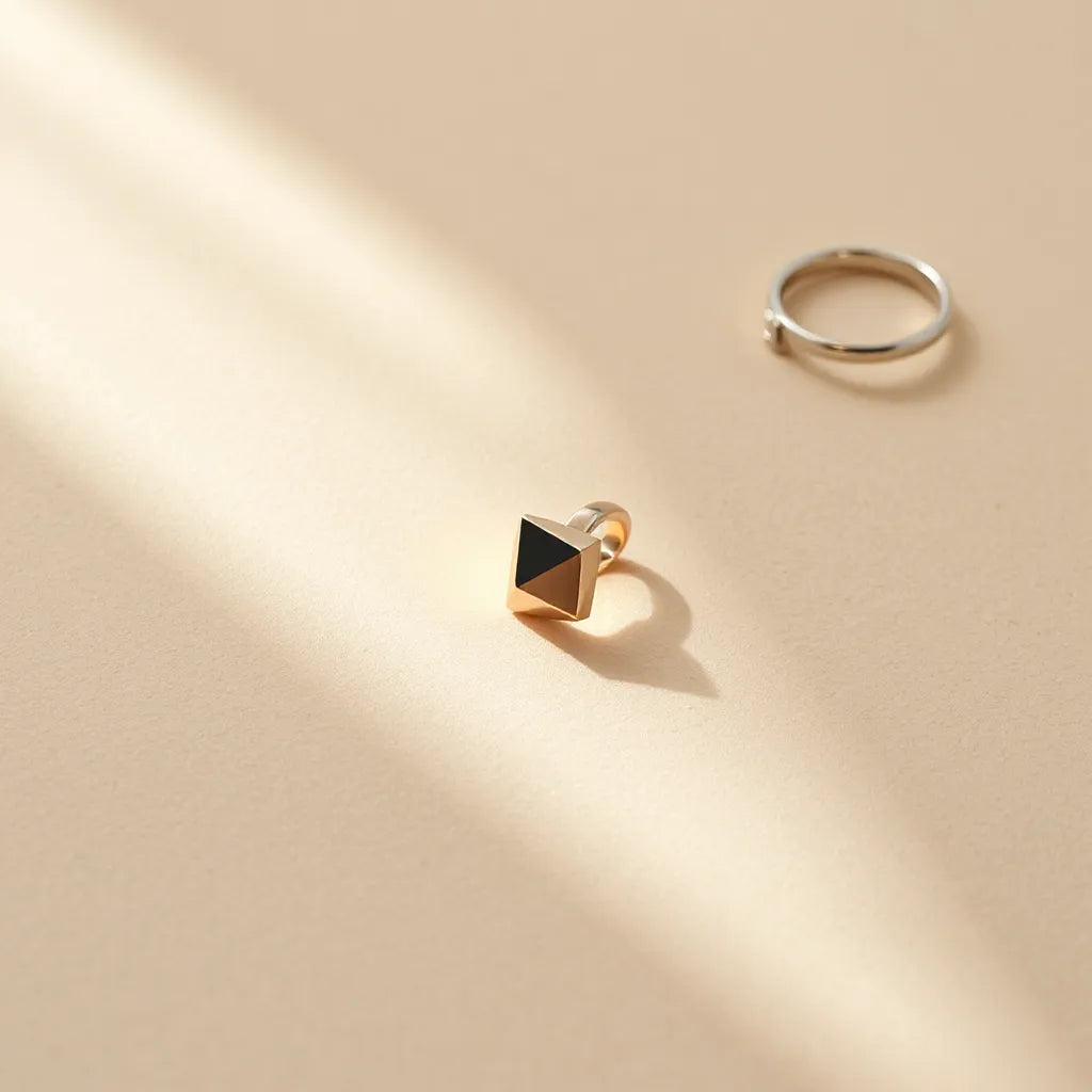 Geometric ring with angular facets displayed on neutral fabric under soft natural light.